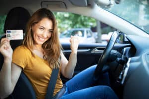 une femme en voiture qui vient d'obtenir son permis de conduire